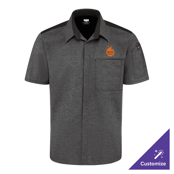 A short-sleeve, button-up charcoal shirt with black shoulder accents, a chest pocket, and an orange logo on the left chest.