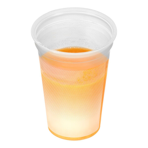 A clear plastic cup partially filled with an orange-yellow liquid, likely a smoothie or juice.