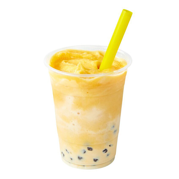 A plastic cup filled with a yellow-orange smoothie, containing black tapioca pearls at the bottom and a yellow straw inserted on top.