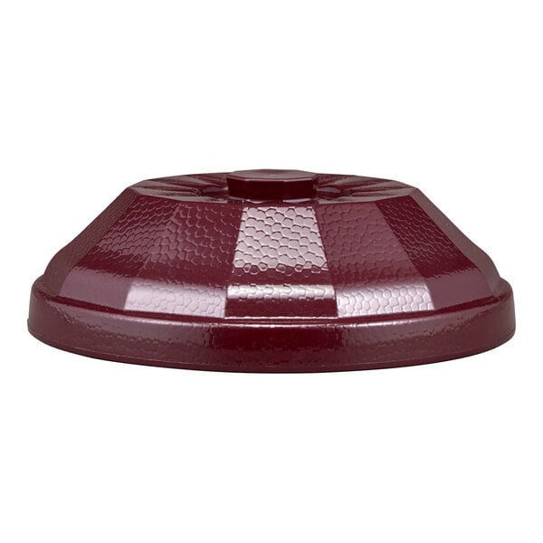 A maroon, textured, dome-shaped plastic cover with a central knob, viewed from the side.
