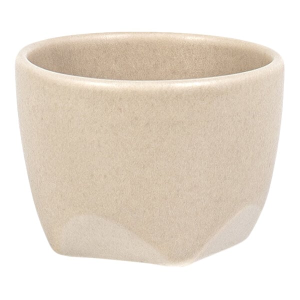 A small, beige, round cup with a slightly flared rim and a smooth matte finish.