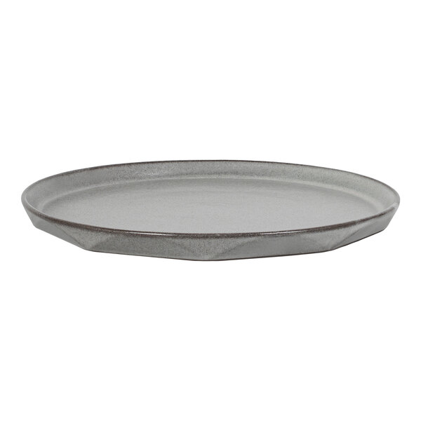 A round, flat, gray plate with a slightly raised edge and a faceted design on the side.