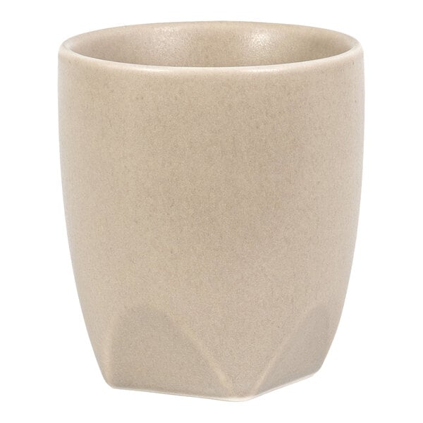 A beige, matte-finish cup with a slightly rounded rim and a subtle geometric base design.