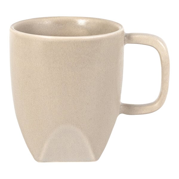 A beige ceramic mug with a square handle and a slightly tapered base.