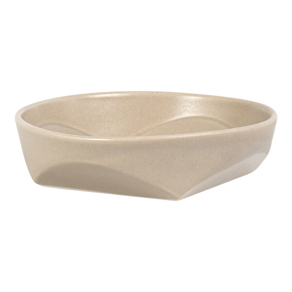 A beige, shallow, round bowl with a geometric, faceted exterior design.