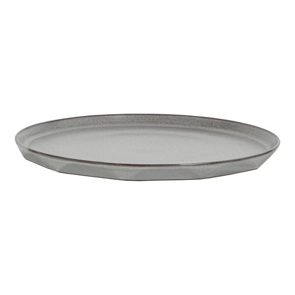 A round, flat, gray platter with slightly raised edges and a subtle faceted design along the rim.
