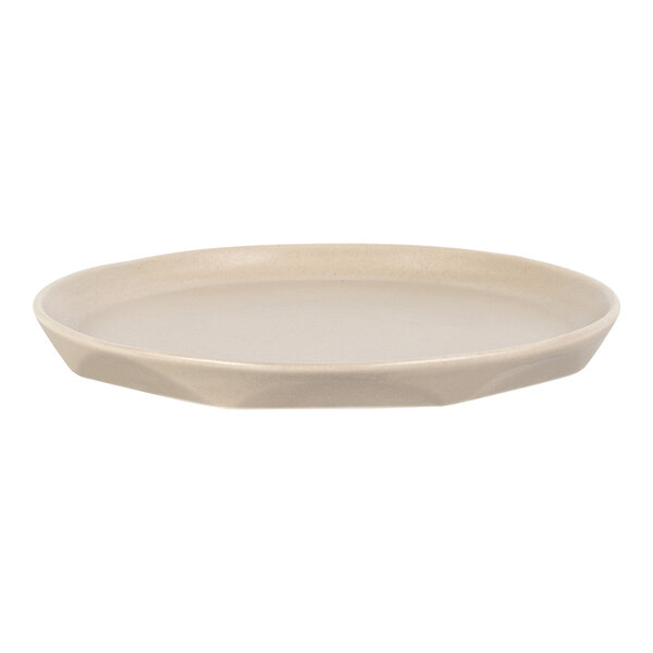 A round, beige porcelain plate with a slightly raised edge and a faceted design on the side.