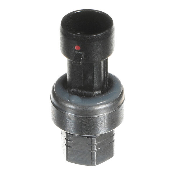 A small cylindrical black and metallic component with a hexagonal base and a round top, featuring a small red dot on the upper section.