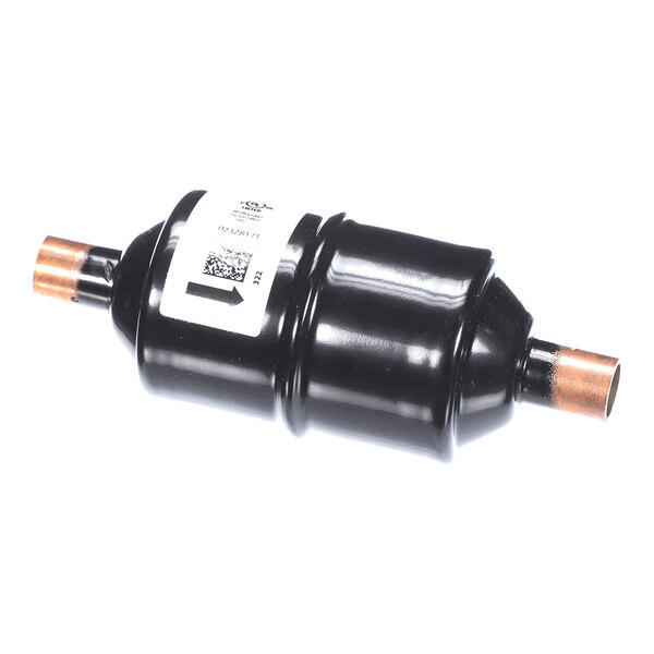 A black cylindrical component with copper pipe fittings on both ends and a white label attached to its body.