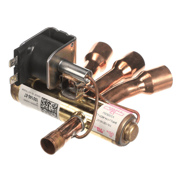 A metallic component with several copper tubes and an attached black electrical coil, likely part of a mechanical or HVAC system.