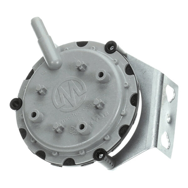 A round, gray mechanical component with multiple protruding nozzles and a metal mounting bracket attached.