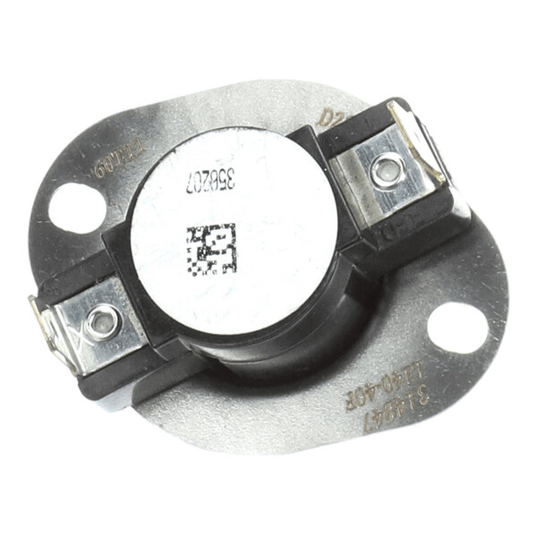 A round metallic component with two electrical terminals and mounting holes on a flat base.
