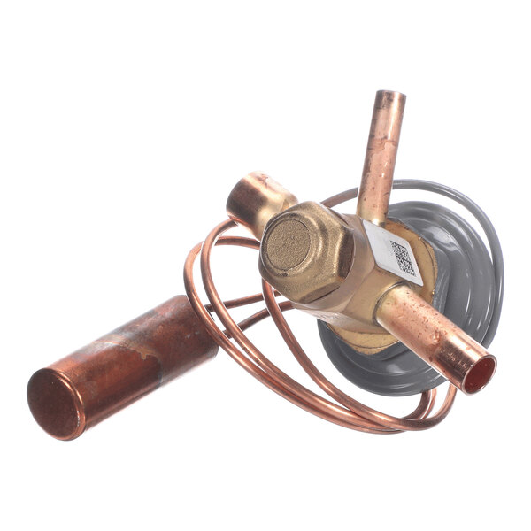 A brass and copper valve component with coiled tubing and cylindrical attachments, photographed on a white background.
