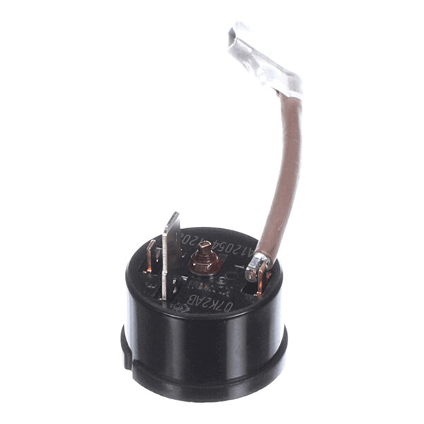 A small cylindrical black electrical component with two metal terminals and a brown wire attached, likely an overload protector or relay.