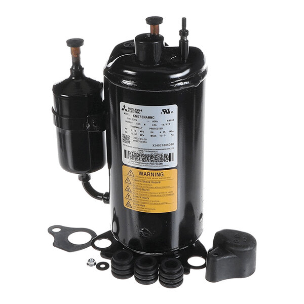 A black cylindrical mechanical component with attached pipes, a label, and several rubber and metal fittings placed around its base.