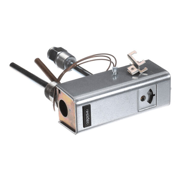A metallic rectangular device with attached wires, a dial, and protruding rods, likely part of a mechanical or electrical system.