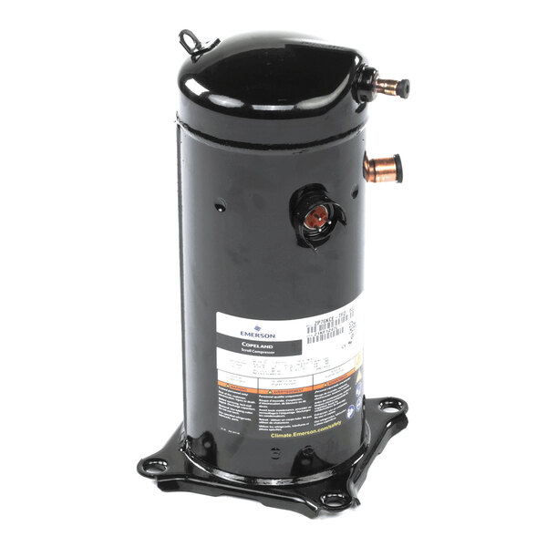 A black cylindrical metal component with copper pipe fittings and a label, mounted on a base with four feet.