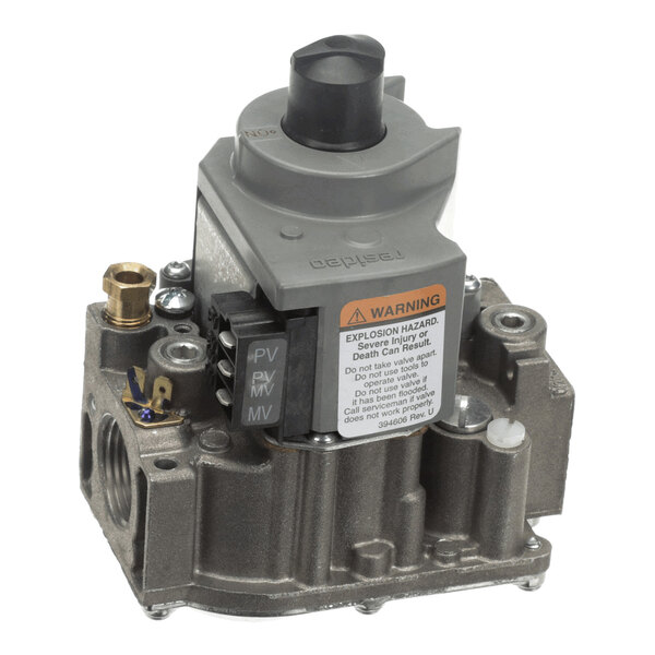 A metallic valve assembly with a gray control knob, electrical terminals labeled PV, MV, and a warning label on the front.