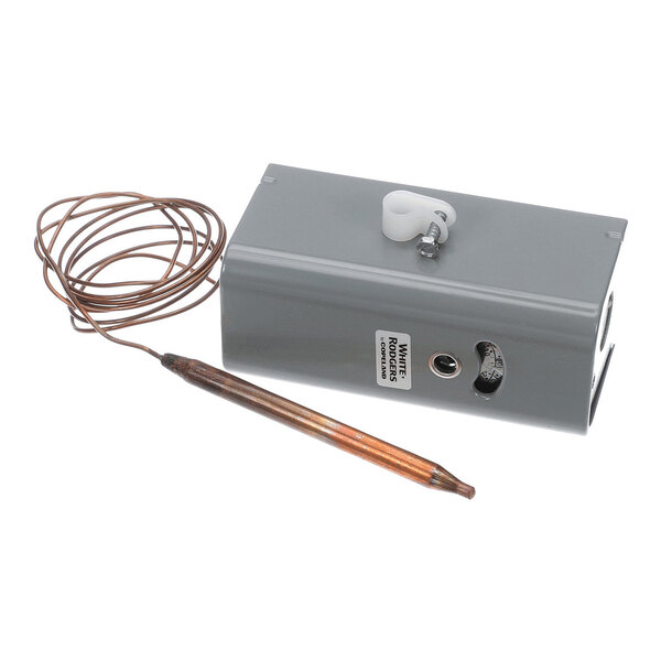 A rectangular gray metal box with a coiled copper wire attached to a cylindrical probe, featuring a small dial and a label on its side.