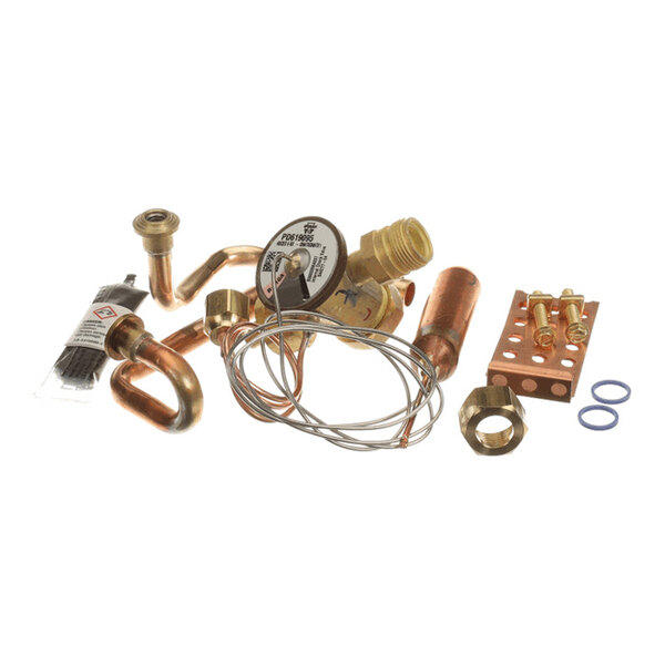 A collection of various copper and brass plumbing or HVAC components, including pipes, fittings, a valve with a dial, wires, and small hardware pieces, arranged on a white background.