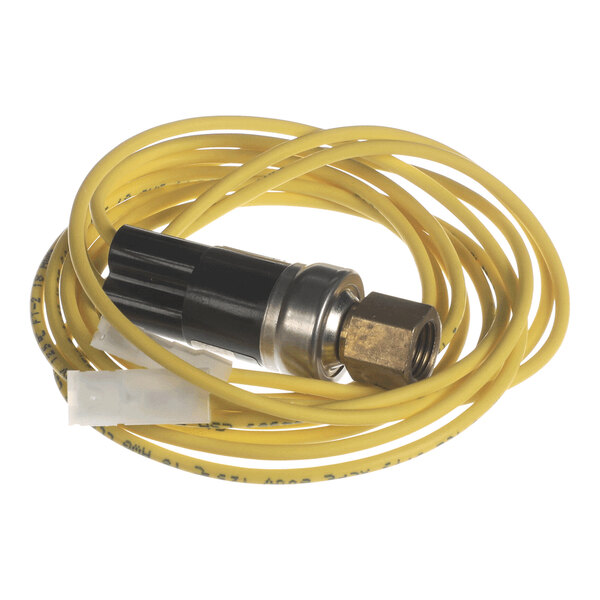 A coiled yellow wire attached to a black and metallic cylindrical component with a brass fitting and a white connector.