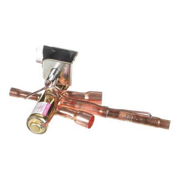 A metallic component with copper pipes and a cylindrical part, likely part of a mechanical or HVAC system.