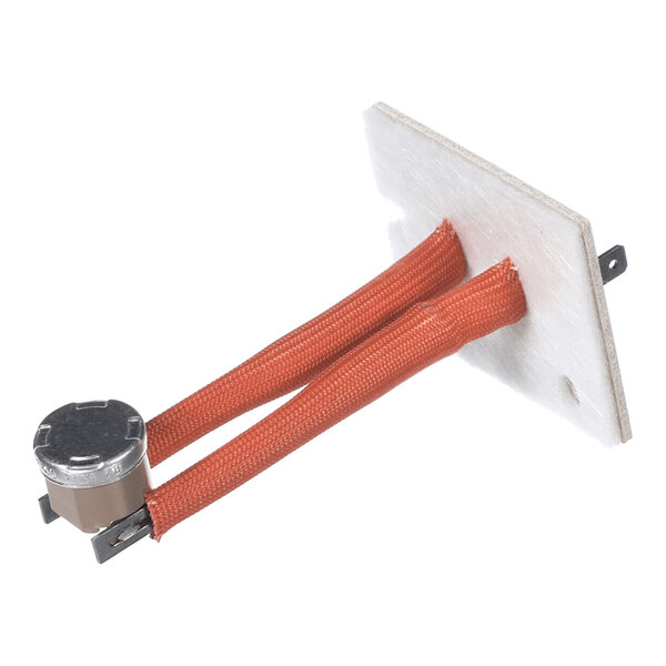 A metal cylindrical component connected to two red insulated wires, mounted on a rectangular white board with metal terminals.