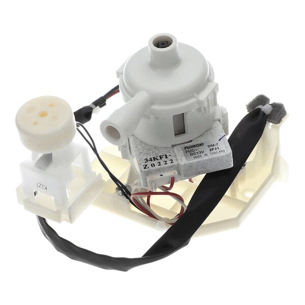 A white plastic and metal mechanical assembly with wires, a cylindrical pump component, and a foam-tipped arm, photographed on a white background.