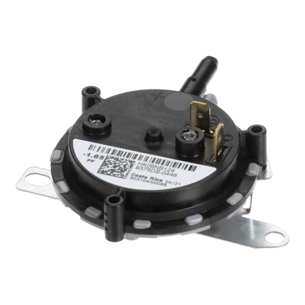 A round black plastic component with metal mounting brackets, electrical terminals, and a barcode label.