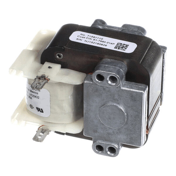 A metal and plastic electrical component with coils, terminals, and a label, likely part of a motor or transformer assembly.