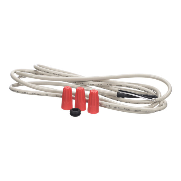 A coiled gray electrical wire with three red wire connectors and one small black ring placed on top.