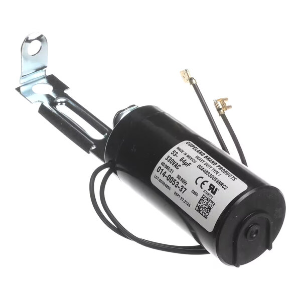 A cylindrical black electrical component with attached wires and a metal mounting bracket, featuring a white label with technical specifications.