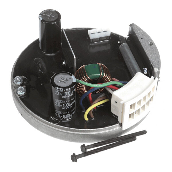 A round electronic control module with capacitors, wires, a coil, a white connector, and two black screws placed in front.