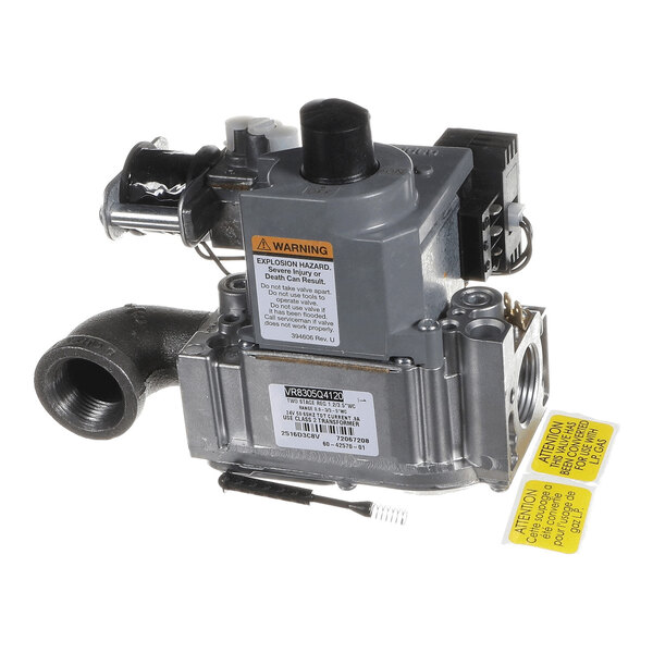 A metallic mechanical valve assembly with warning labels and various connectors visible.