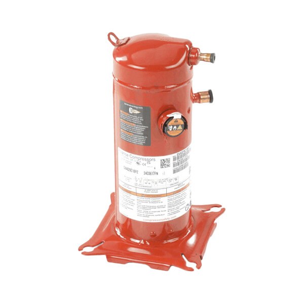 A red cylindrical metal component with two pipe fittings and a base, featuring several labels and a gauge on its side.