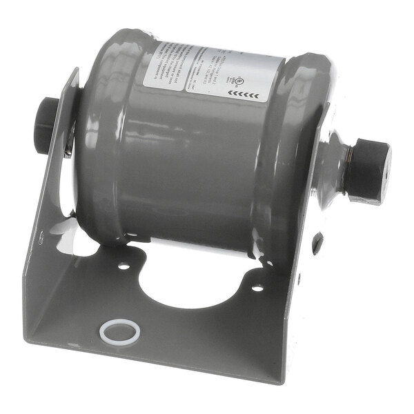A cylindrical metal component mounted on a bracket with a label and two threaded connectors on either end.
