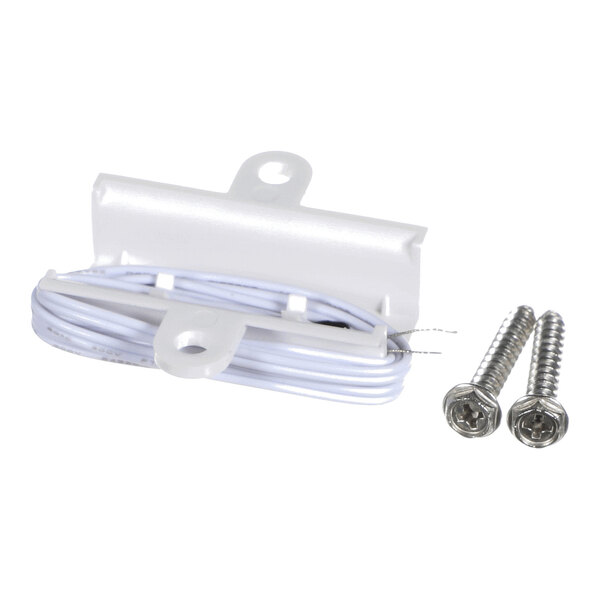 A white plastic component with attached coiled wire and two metal screws placed beside it.