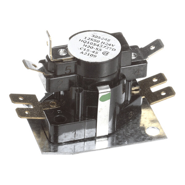 A small electrical component with multiple metal terminals mounted on a metal base plate, featuring a round label on top with technical specifications.