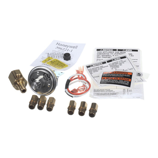 A collection of brass fittings, a gauge, wiring, and instruction sheets arranged on a white surface.