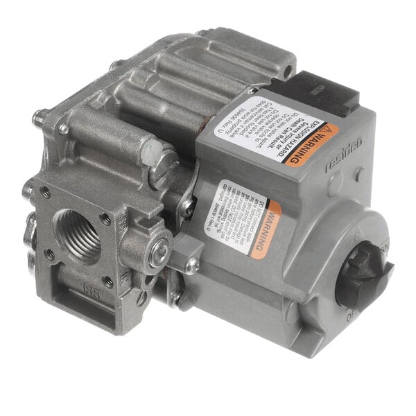 A metallic gas valve with threaded ports, warning labels, and a control knob.