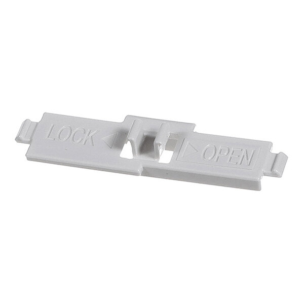 A small, rectangular, gray plastic piece with raised text indicating 'LOCK' and 'OPEN' with arrows, and a central sliding mechanism.