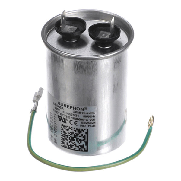 A cylindrical metal capacitor with two terminals on top and a green wire attached to its side.