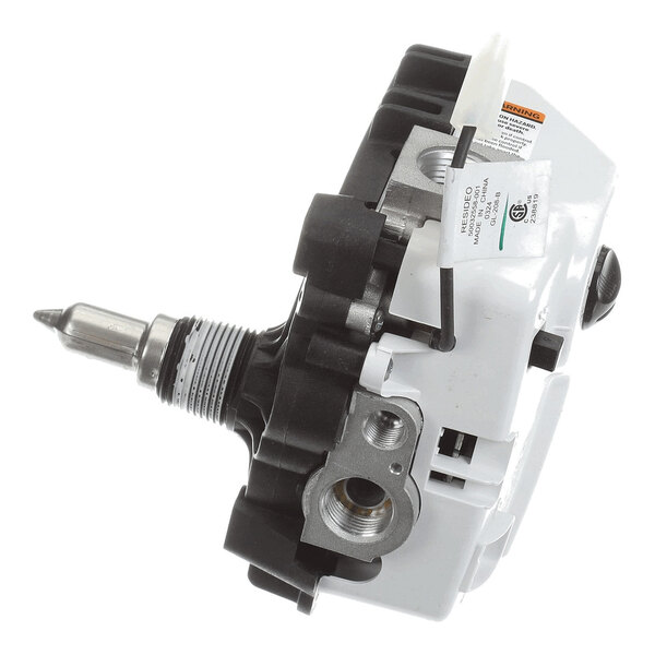 A close-up view of a mechanical gas control valve assembly with metal and plastic components, visible labels, and connection ports.