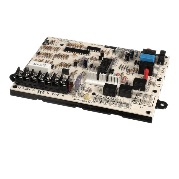 An electronic circuit board with various components including resistors, capacitors, relays, connectors, and terminal blocks mounted on a white base.