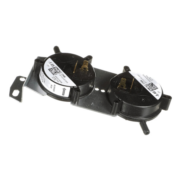 A metal mounting plate with two round black plastic components, each featuring electrical terminals and labeled stickers, likely part of an air pressure switch assembly.