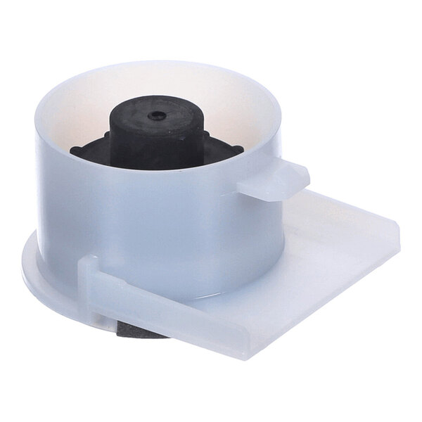 A cylindrical plastic and black component with a flat rectangular extension, likely part of a mechanical assembly.