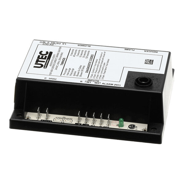 A rectangular electronic control module with labeled terminals, a green indicator light, and a white label on top displaying technical information.