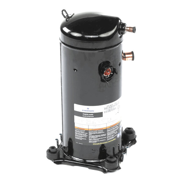A black cylindrical metal component with copper pipe fittings and a label, mounted on a base with four feet.