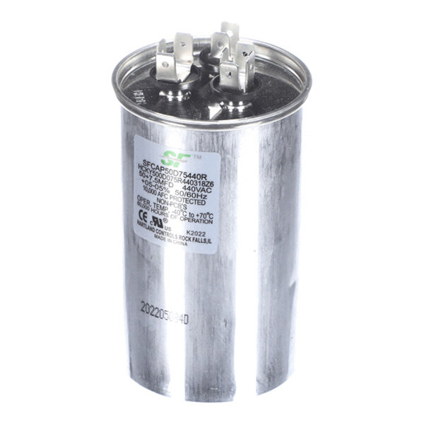 A cylindrical metallic capacitor with three electrical terminals on top and a label displaying technical specifications.