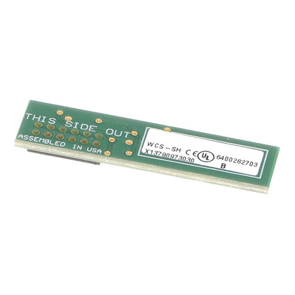A rectangular green circuit board with gold contact points, white printed text, and a white label with technical information.